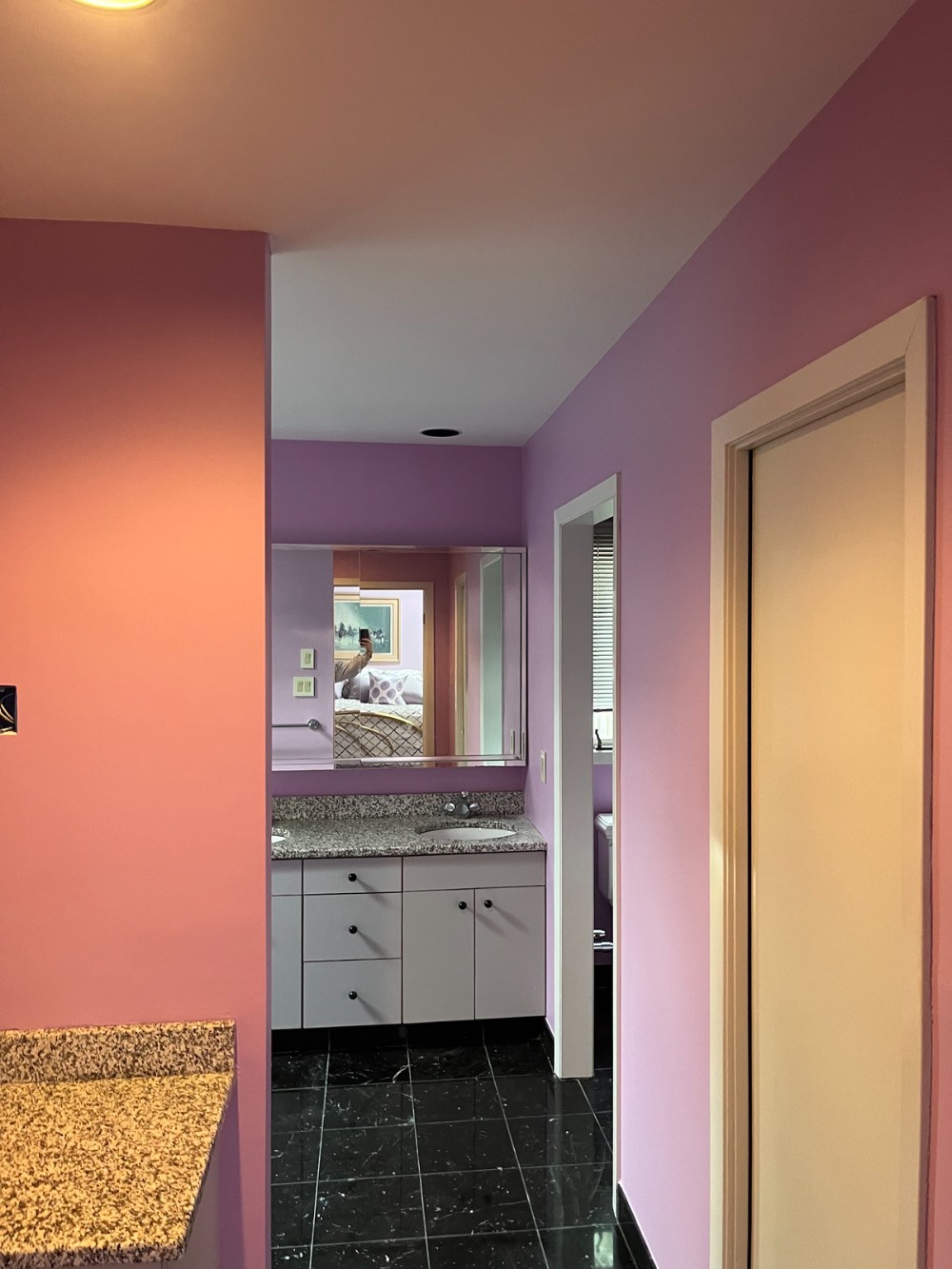 Bright Purple bathroom walls white vanity trim and doors hanging mirror