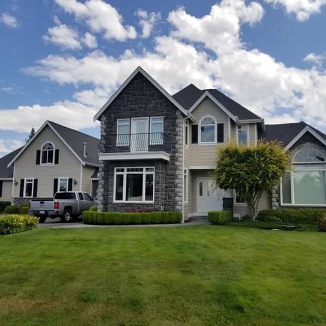 Two Story Home with two-toned stone decor and shutters