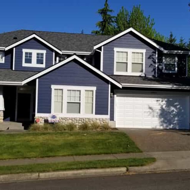 Two Story Home with Front Porch Railing and double car garage.