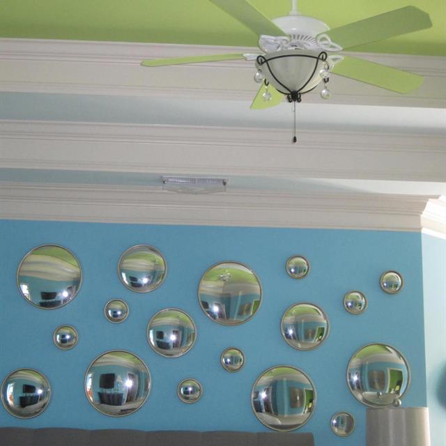 Blue accent wall with scatterd circular mirrors.