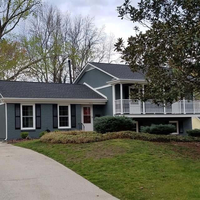 Blue house with a driveway and front lawn