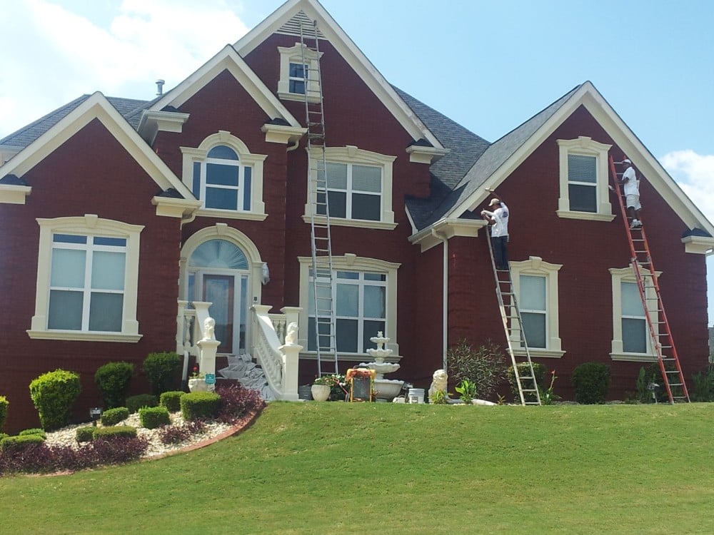 Professional painters applying a fresh coat of paint to a brick home in Jonesborough, TN, exemplifying our expertise in residential and commercial painting services provided by Five Star Painting.