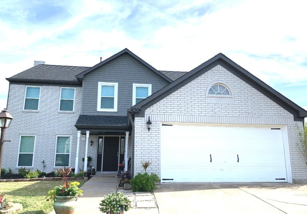 Complete exterior view of a two-story home featuring a combination of brick and siding, showcasing the impeccable painting craftsmanship of our Five Star Painting services in Pittsburgh, PA.