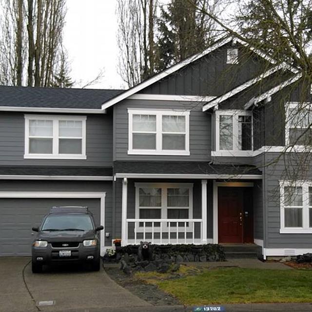 Two-tones grey two story exterior with white trim and front porch railings