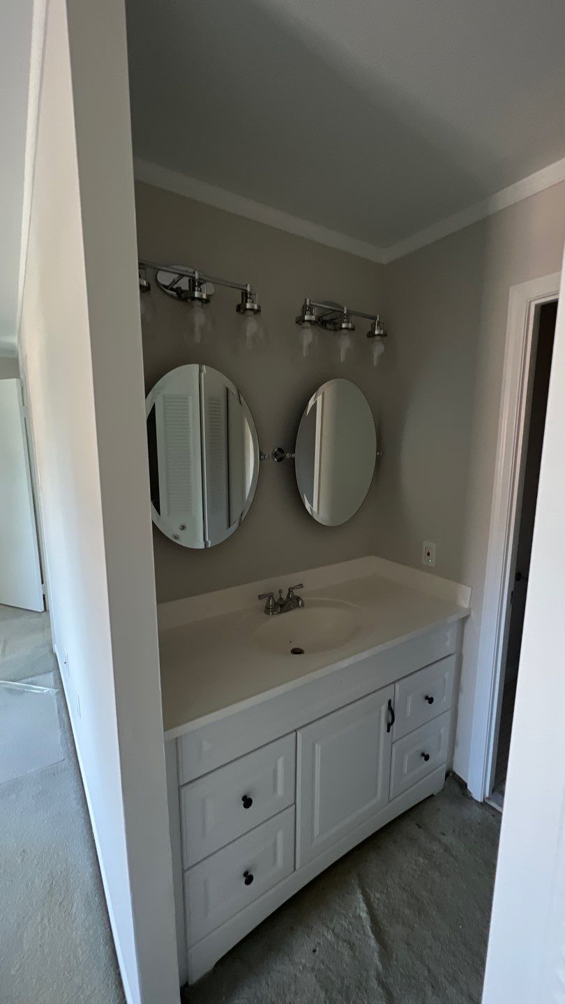 Grey Master Bath Vanity with New Oval Mirrors and Modern Updated Lighting.