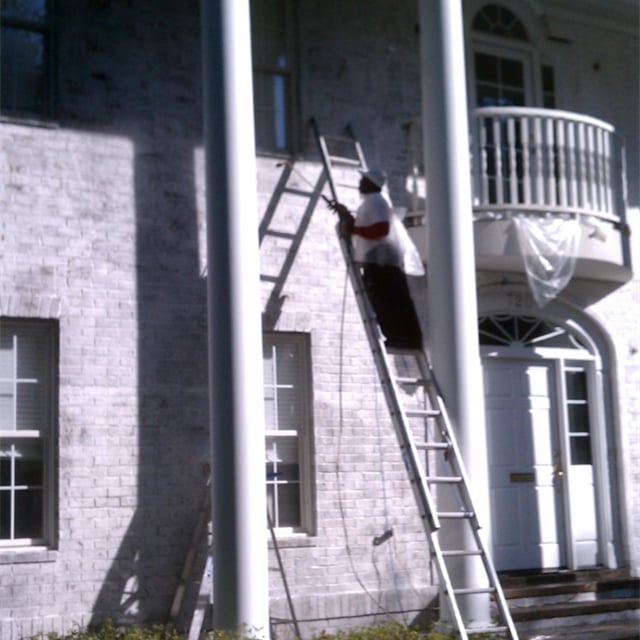 House exterior painting using a ladder