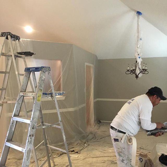 A painter prepping to remove a popcorn ceiling from a home.