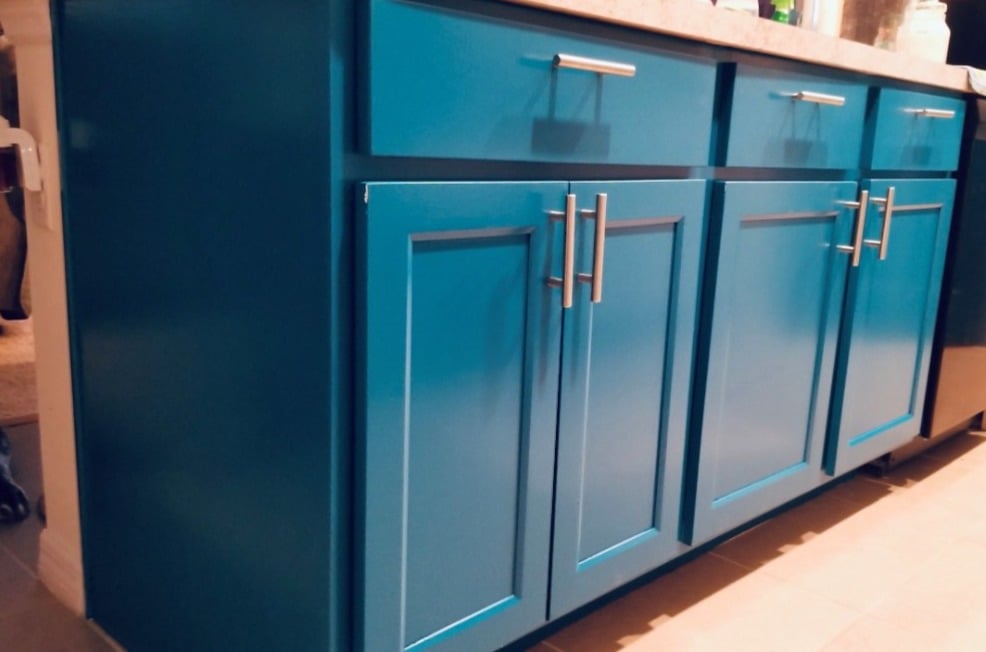 Vibrant blue painted kitchen cabinets add a pop of color and style, demonstrating the transformative power of our residential painting services.