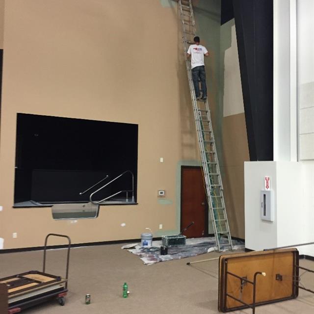 Painter on a ladder in a gymnasium