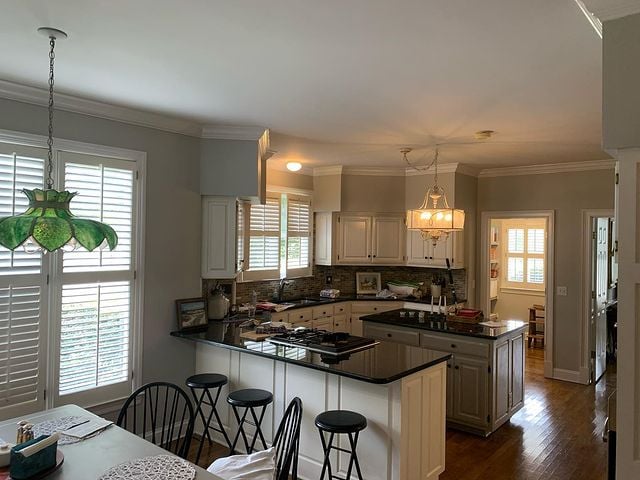 Rosegrey Kitchen with white cabinets and black countertops