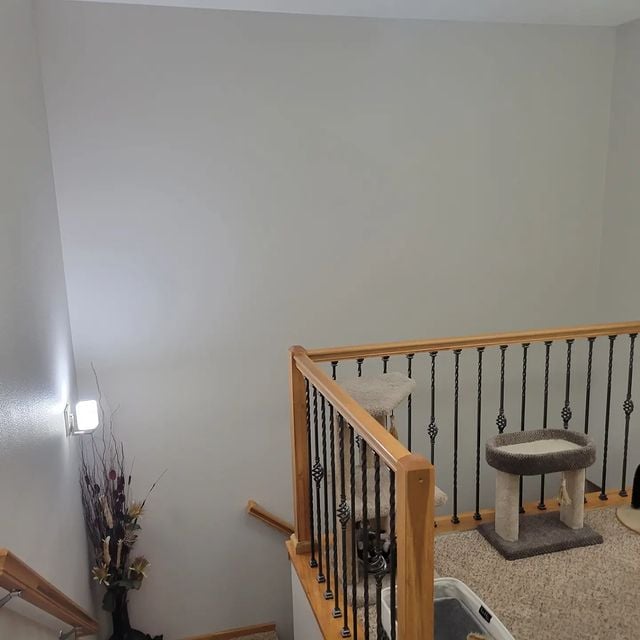 Stairwell with light walls and natural wood look handrails