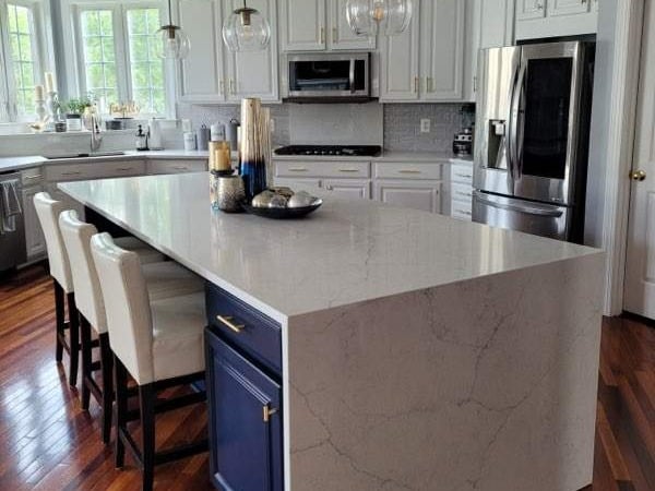 Updated Kitchen with Waterfall Countertop and White and Blue Cabinets