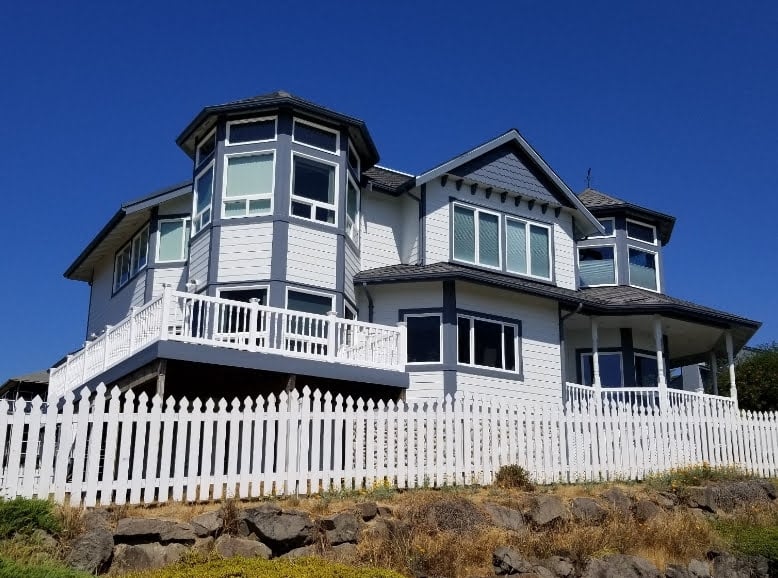 Two Story Victorian Style home with porch railings and picket fence