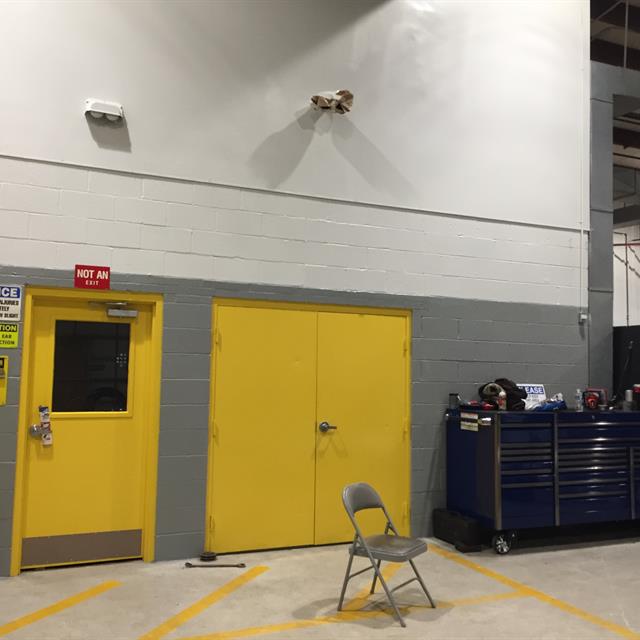 Interior painting yellow doors in a manufacturing facility