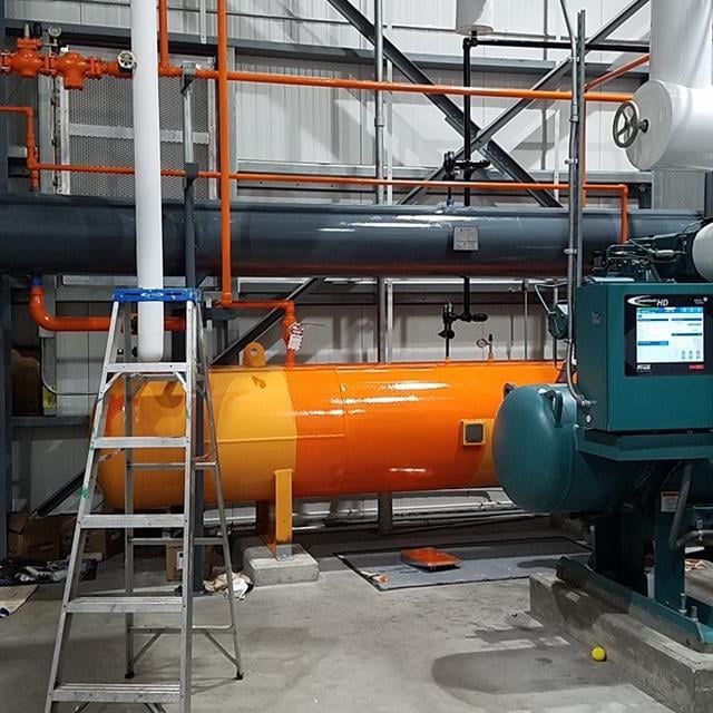 Warehouse with yellow and orange machinery and pipes