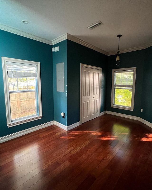 blue painted bedroom walls and large windows with hardwood flooring