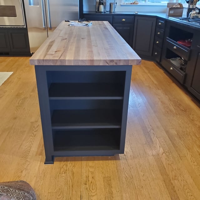 brown kitchen with hardwood floor and wood island