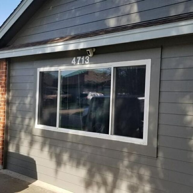 gray exterior home with brick pillars 