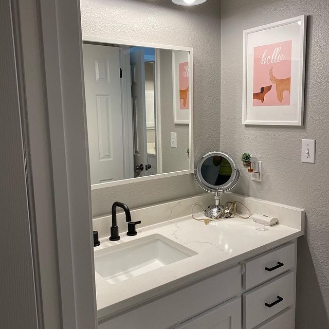 grey bathroom with with marble counter and mirror