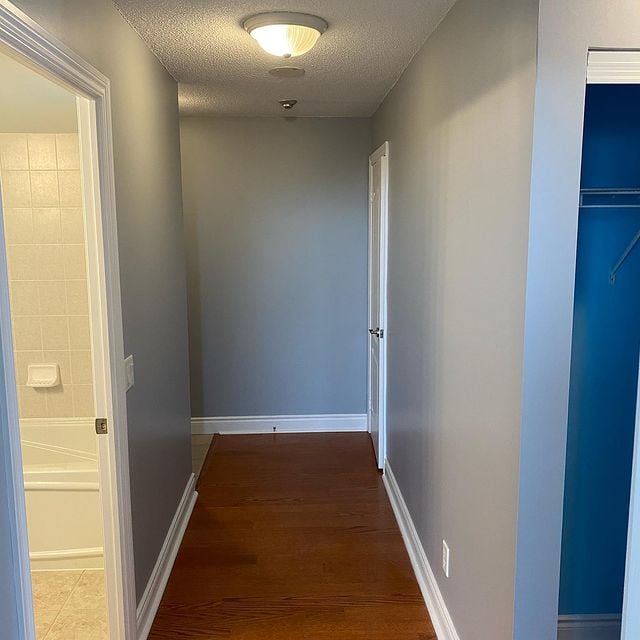 grey hallway with white accents and hardwood flooring