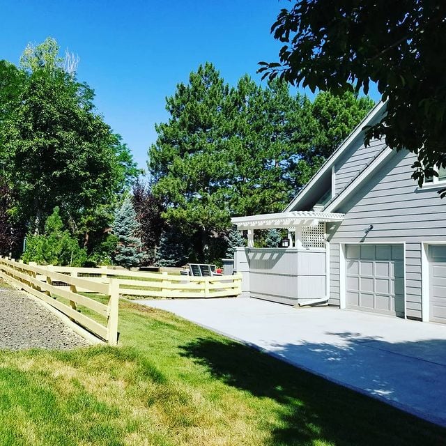 grey house with white accents and a yellow fence