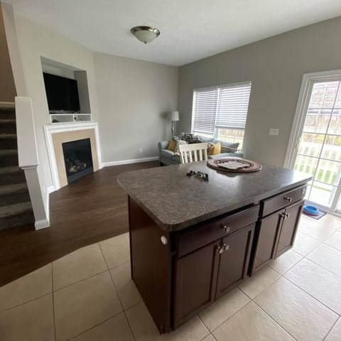 grey room with an island counter and tile flooring