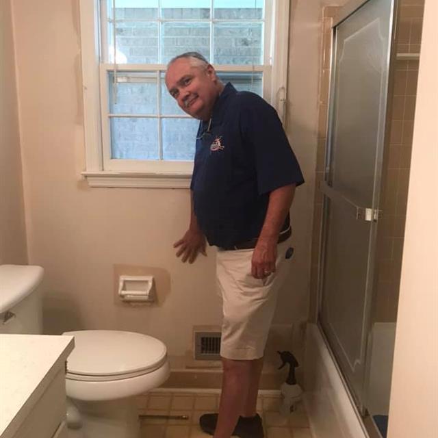 man holding wall in bathroom