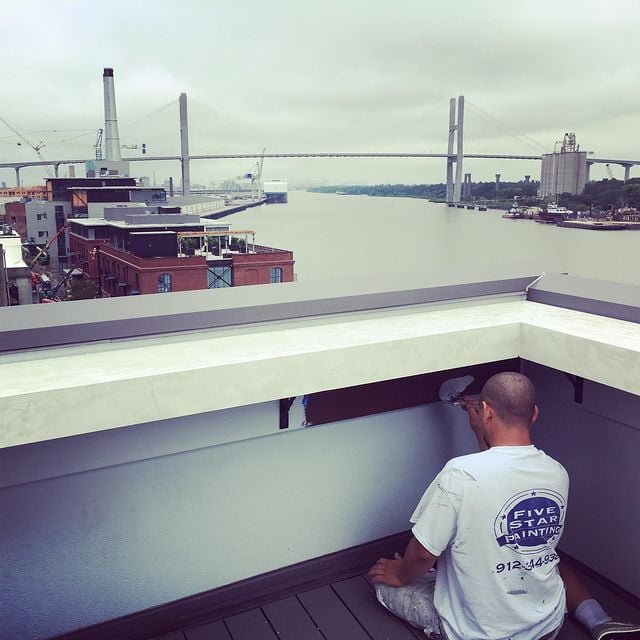 man working on building next to river