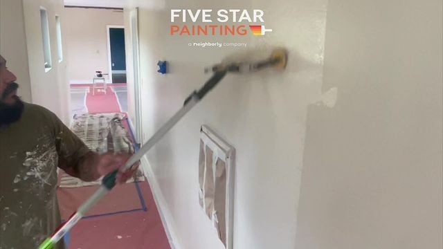 painter painting a wall white