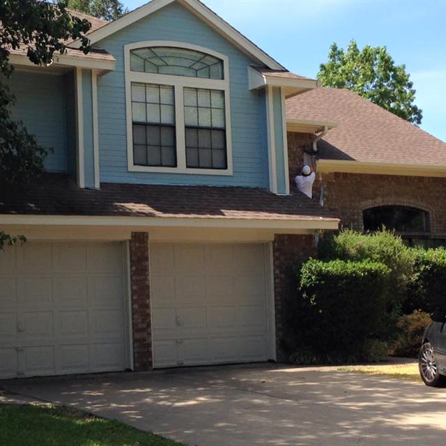 painter working on front of home