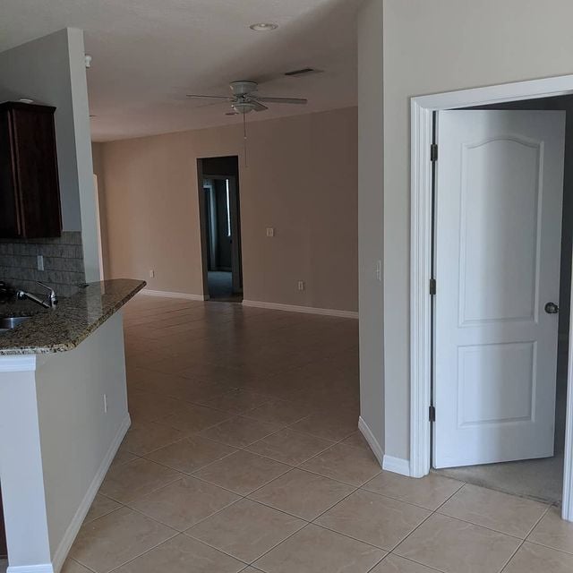 tan room with white moldings and tile flooring