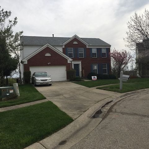 white and brick home with car