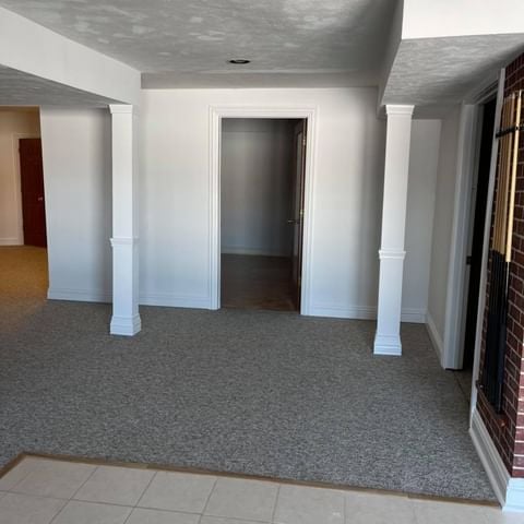 white basement with pool sticks on a brick wall