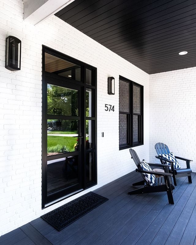 white brick house with black accents and porch