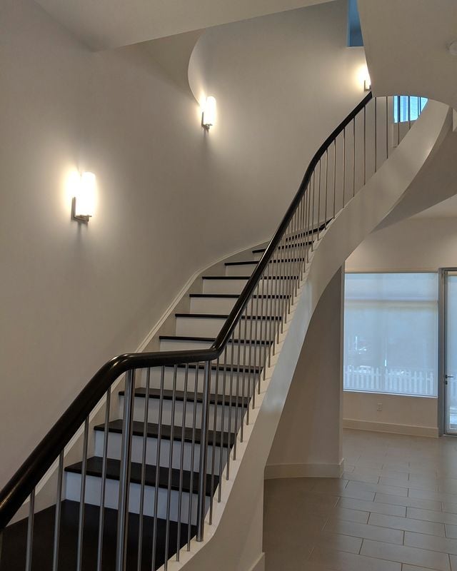 white house with dark wooden stairs and hand railing