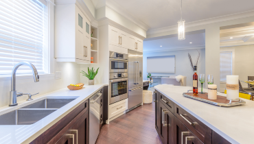 Photo of a large kitchen with white and brown accents.