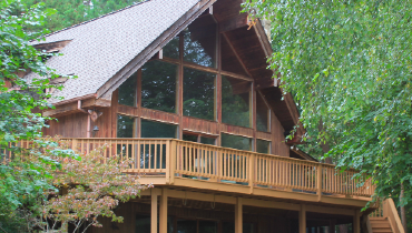 Photo of a wooden cabin surrounded by trees.