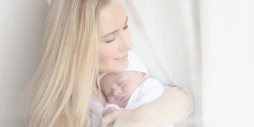 Photo of a woman holding a sleeping baby