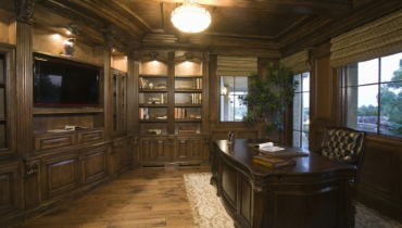 Traditional home office with wooden desk and bookshelves.