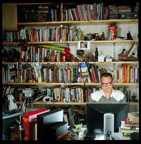 Man Sitting in an Office Surrounded by Books Man Sitting in an Office Surrounded by Books