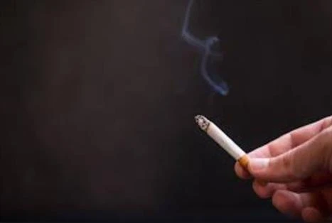 painting while breastfeeding, low voc paint for breastfeeding Photo of a hand holding a lit cigarette