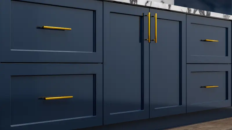 Navy kitchen cabinets with long gold handles.