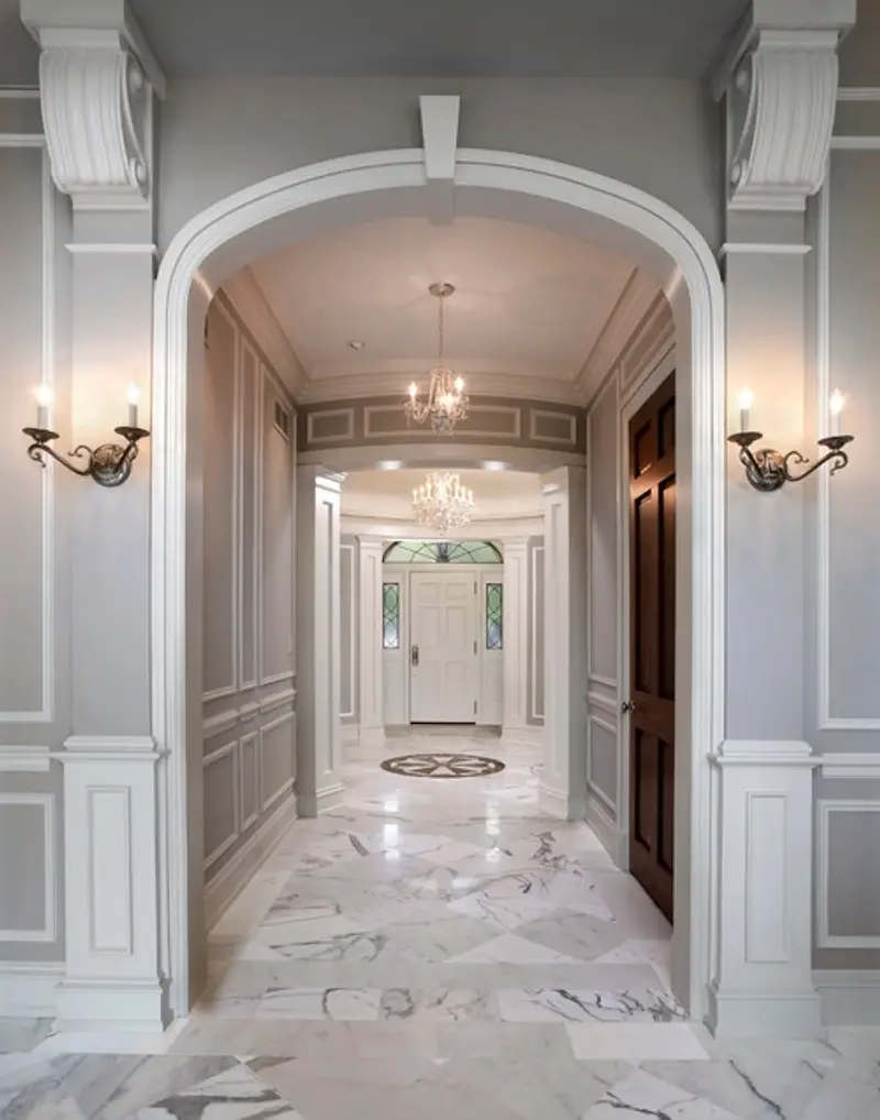 Hallway with marble floors leading to a front door.