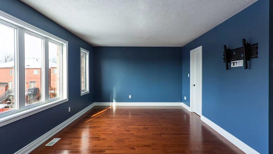 Living room painted blue with shiny wooden floor.