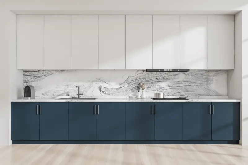 Two-toned kitchen with white and navy cabinets paired with a marble back panel.