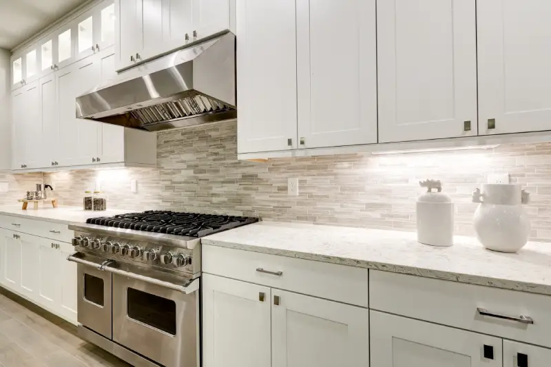 Kitchen interior with white cabinets paired with a steel stove.
