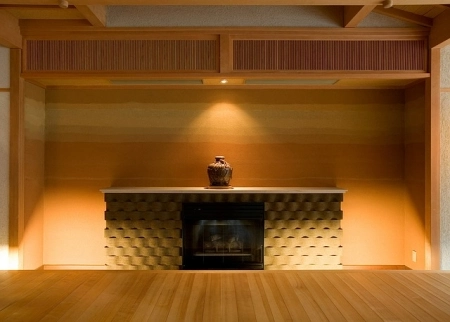 Man Cave Design Tips: Warm Tones A modern fireplace with textured surround, warm lighting, and a single vase on a mantle.