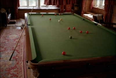Man Cave Design: Billiard Table A billiards table with cues and balls in a vintage room with patterned carpet.